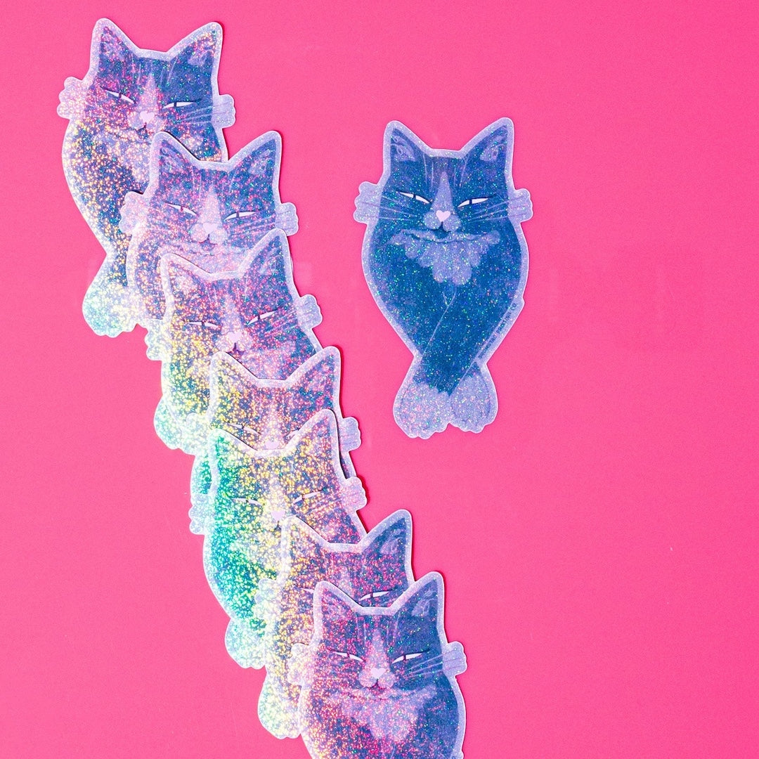Glittery cat stickers on a pink background