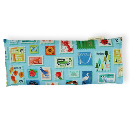 Pillow with colorful stamp design on a white background