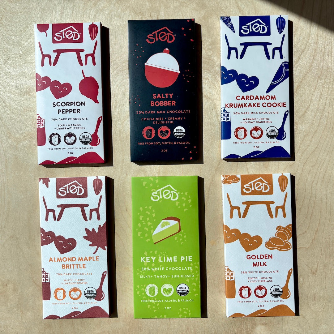 Six different chocolate bars from Sted on a wooden surface