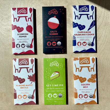 Six different chocolate bars from Sted on a wooden surface