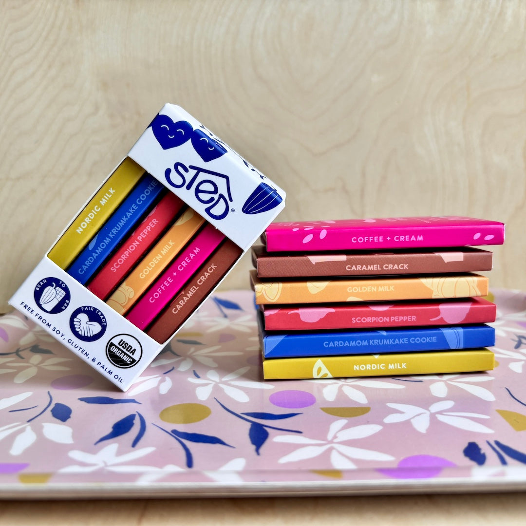Packaged mini chocolate bars with colorful labels on a floral-patterned surface