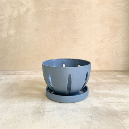 Blue ceramic berry bowl on a wooden background 