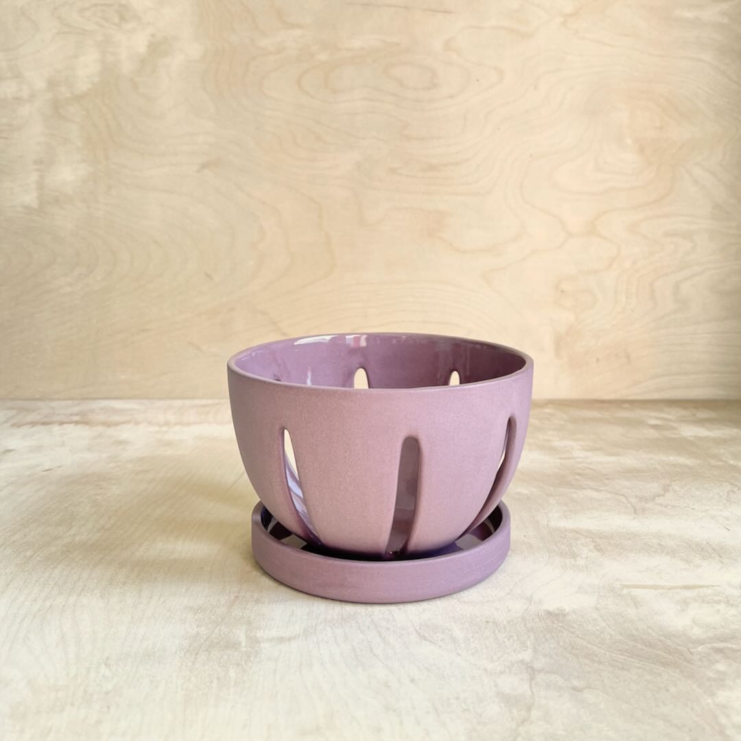 Purple ceramic berry bowl on a wooden background