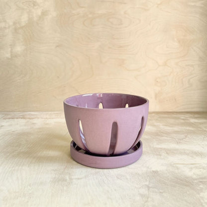 Purple ceramic berry bowl on a wooden background