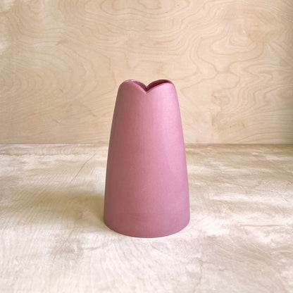 cranberry colored vase on a light wooden surface