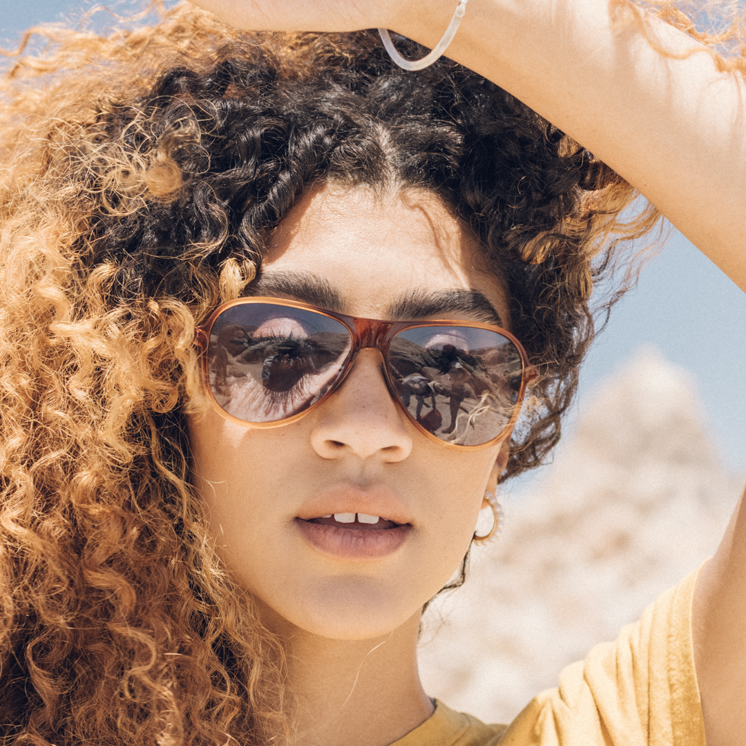 Woman wearing sunglasses with a blurred natural background