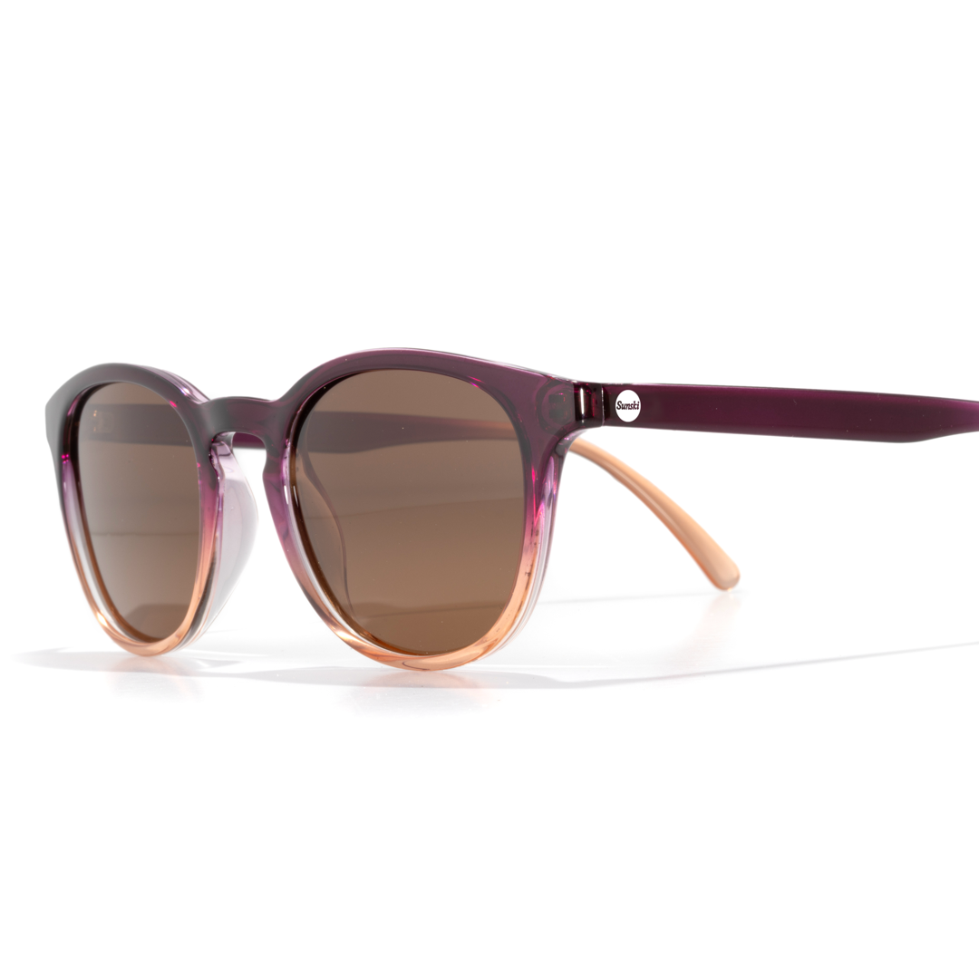 Sunglasses with a purple frame and brown lenses on a white background
