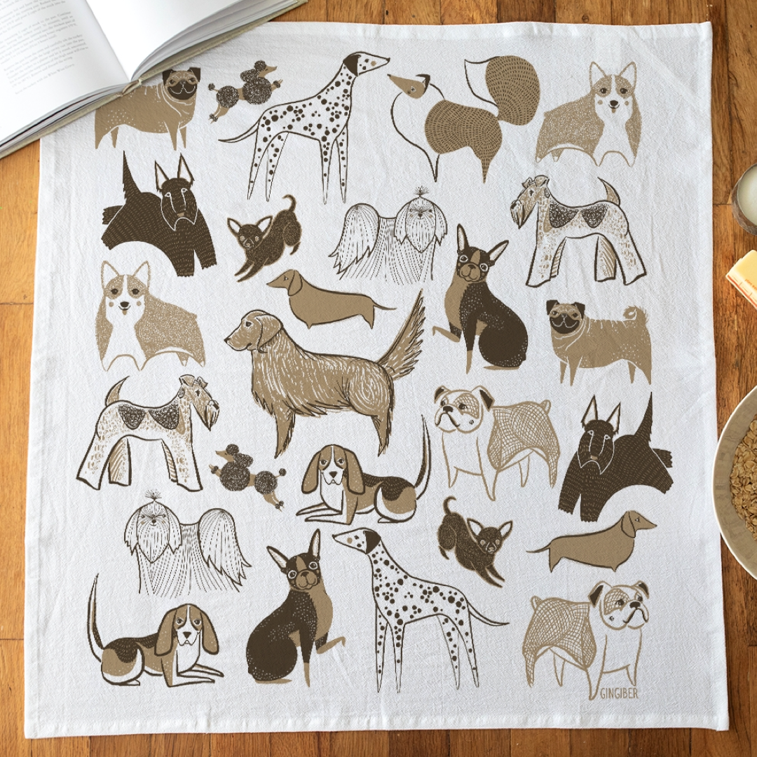 White towel with brown illustrations of dogs on a wooden surface