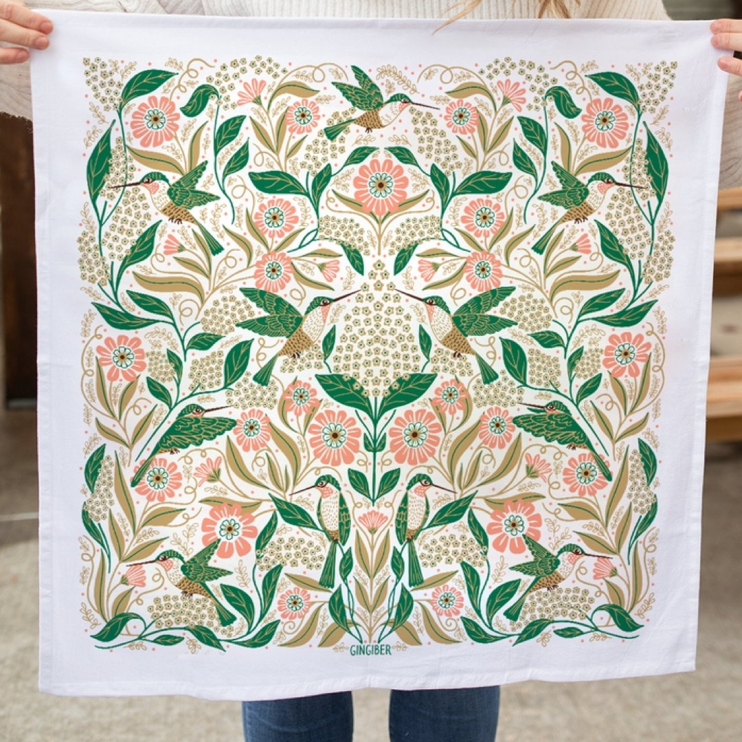 Floral and hummingbird patterned towel held by a person