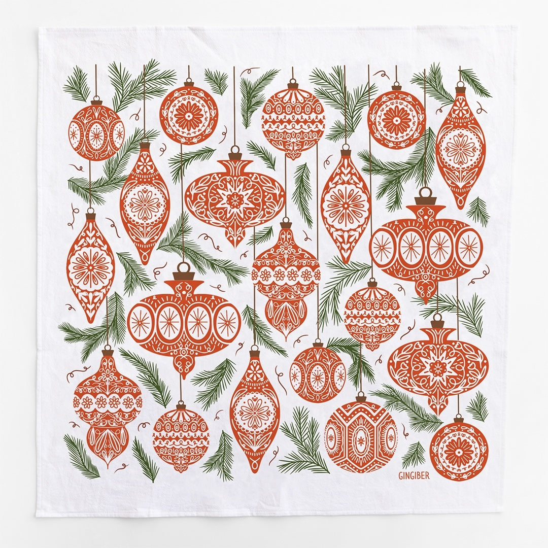 A square white kitchen towel featuring a red Christmas ornaments and green leaves pattern