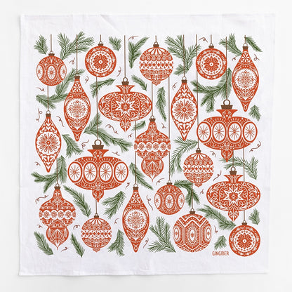 A square white kitchen towel featuring a red Christmas ornaments and green leaves pattern