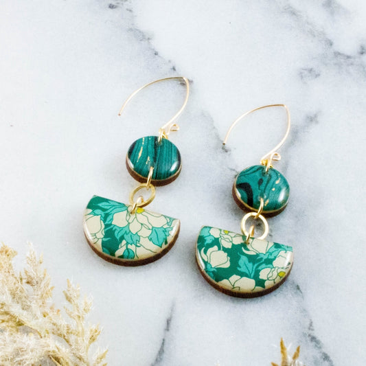 Teal floral earrings on a marble surface 