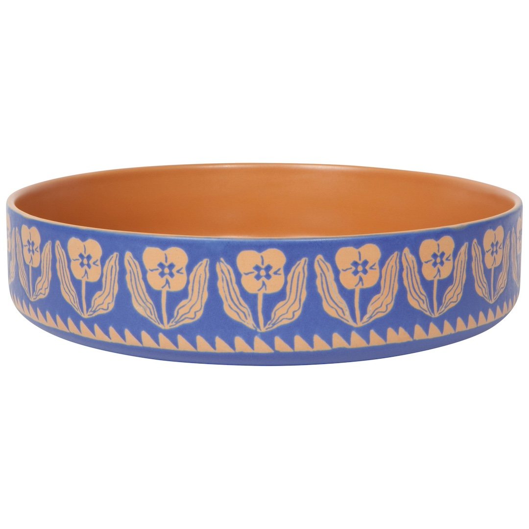 orange serving bowl with purple on the outside and a floral pattern
