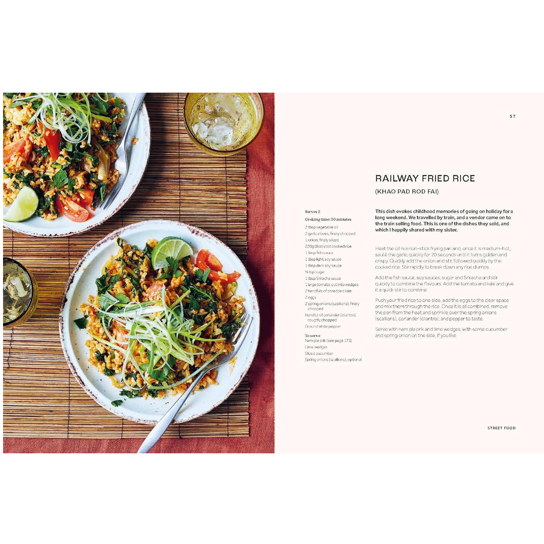 An open cookbook spread showing a recipe for Railway Fried Rice. The left page features a photograph of two plates of prepared fried rice with lime wedges on a bamboo mat, and the right page contains the recipe text on a pale pink background.
