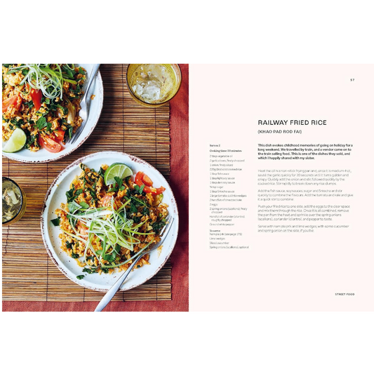 An open cookbook spread showing a recipe for Railway Fried Rice. The left page features a photograph of two plates of prepared fried rice with lime wedges on a bamboo mat, and the right page contains the recipe text on a pale pink background.