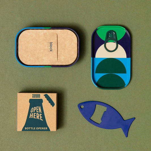 A fish shaped bottle opener and the tin packaging it came in