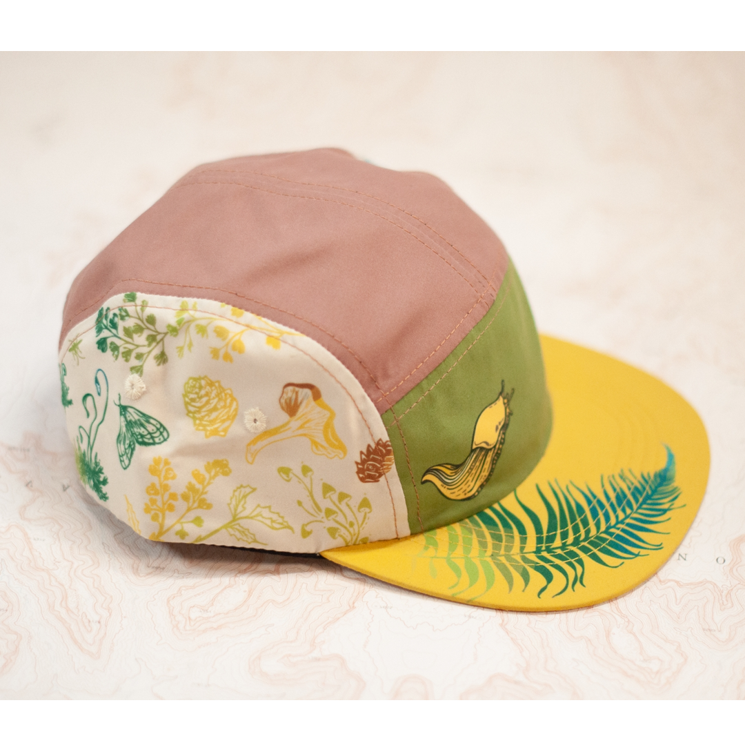 Colorful cap with nature-themed patterns on a textured surface