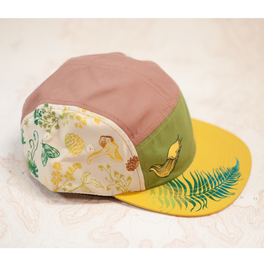 Colorful cap with nature-themed patterns on a textured surface