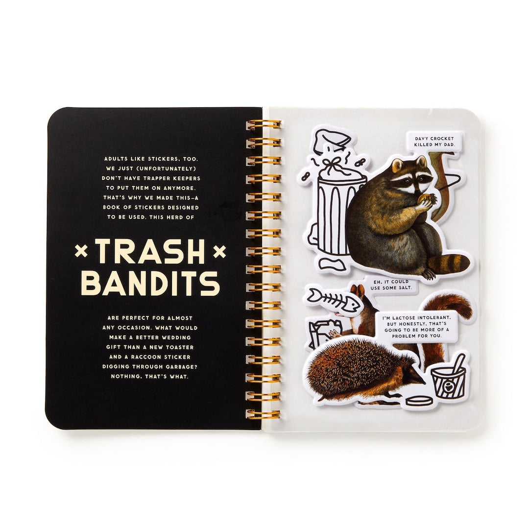 An open spiral-bound sticker book titled 'Trash Bandits' on a white background. The left page is black with white text, and the right page shows several cartoon animal stickers including a raccoon, a squirrel, a fish skeleton, and a trash with a speech bubble.