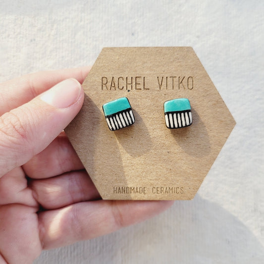 Turquoise and black striped earrings on a Rachel Vitko branded card.