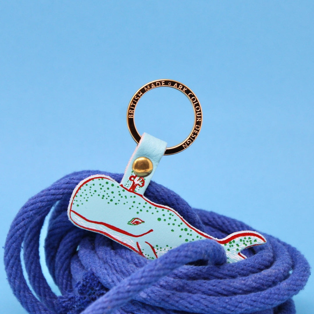blue humpback whale made from leather hanging on a gold ring