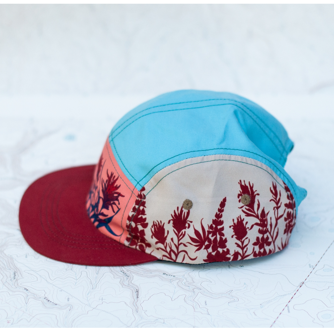 Color-blocked cap with floral pattern on a textured white background