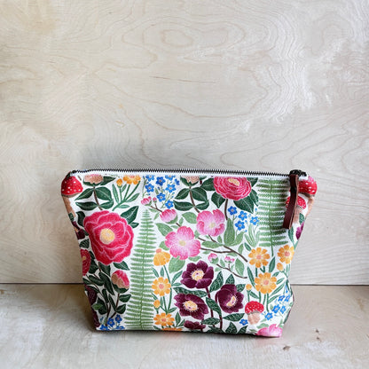 White Forest floral patterned pouch on a wooden surface