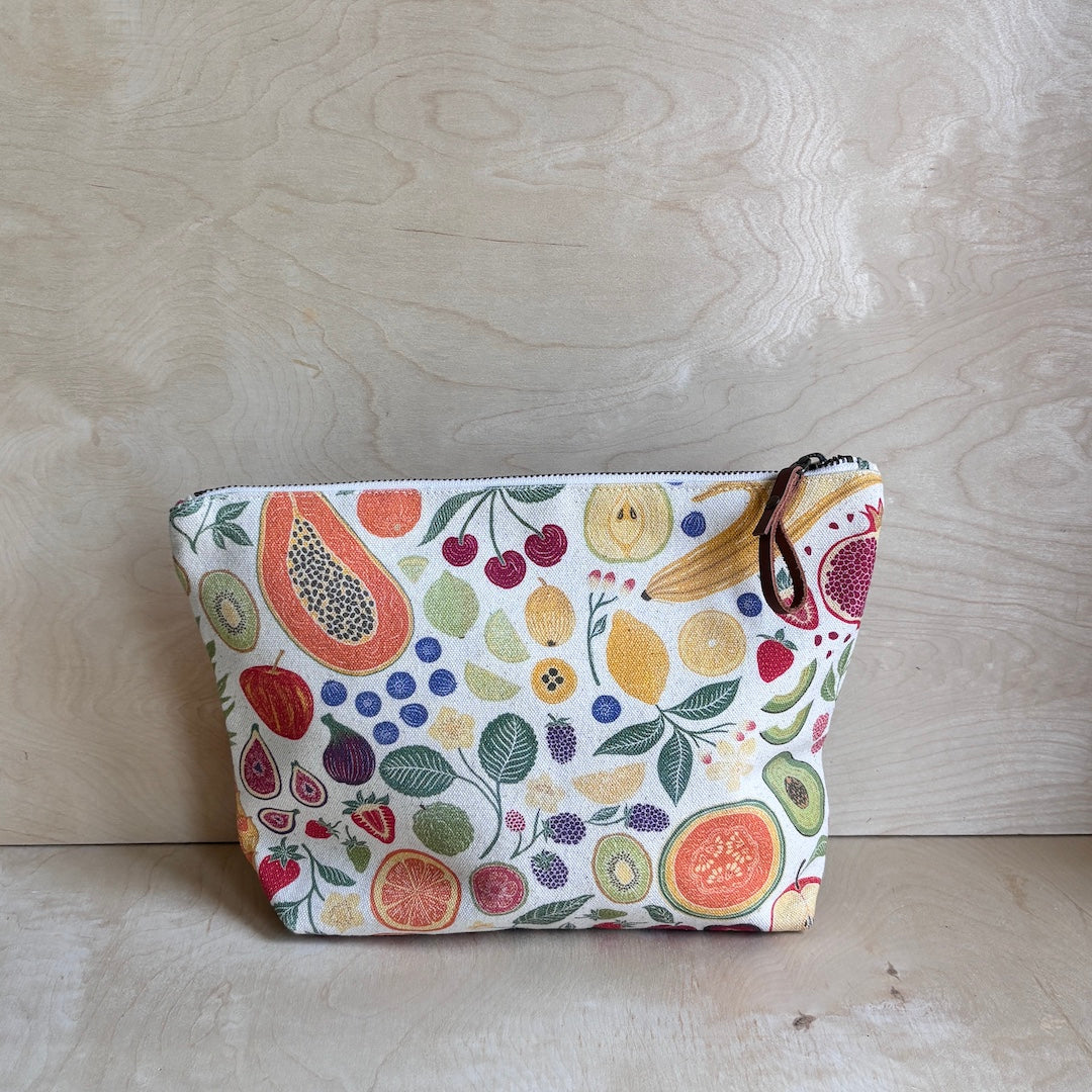 White fabric pouch with fruit pattern on a wooden surface
