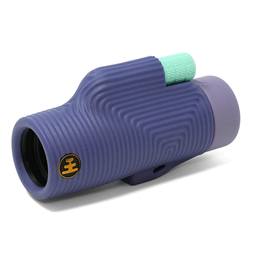 A monocular with a textured purple body, a light purple eyecup, and a mint green textured focus knob, shown on a white background.